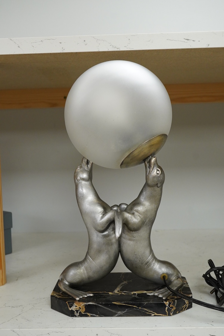 After Louis Carvin (French, 1875-1951) a twin seal lamp with circular frosted glass shade, 34cm high